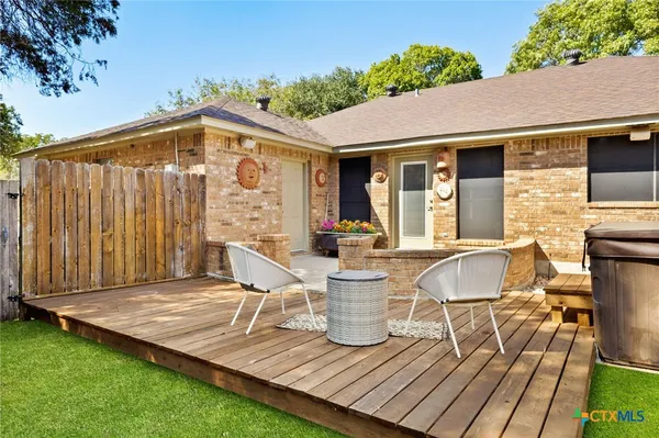 a view of a patio with table and chairs potted plants with wooden fence
