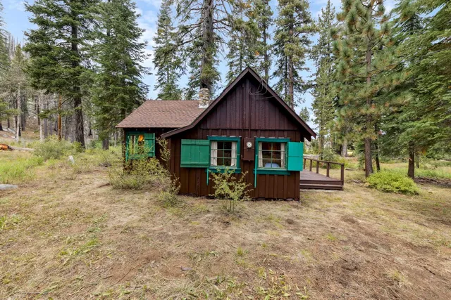 a front view of a house with a yard and tree