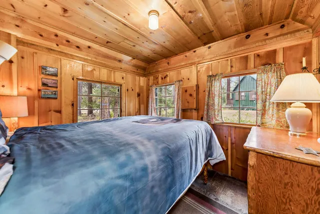 a bed sitting in a bedroom next to a window