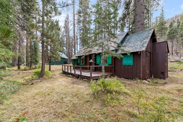 a view of a house with a yard and large trees