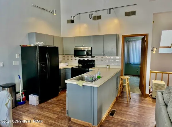a kitchen with stainless steel appliances a refrigerator and a stove top oven