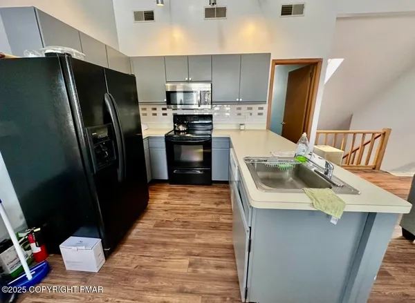 a kitchen with stainless steel appliances a refrigerator sink and stove