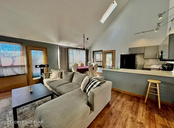 a living room with furniture wooden floor and a flat screen tv