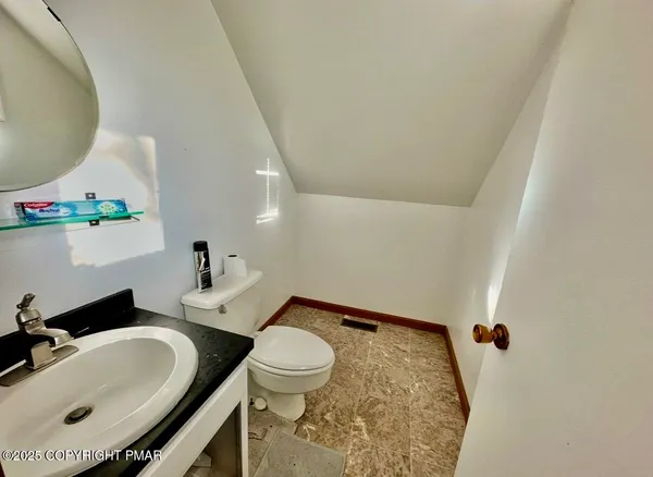 a bathroom with a sink mirror vanity and toilet