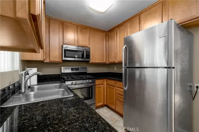 a kitchen with granite countertop a refrigerator stove and microwave