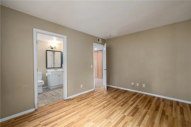 a view of a room with wooden floor and a bathroom