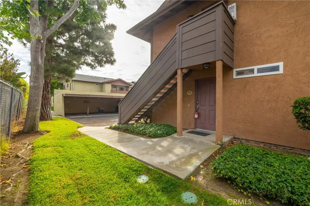 a view of an house with backyard and a tree
