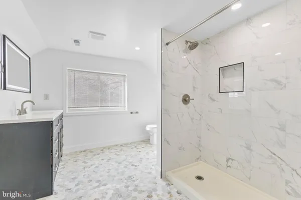 a bathroom with a shower sink and mirror