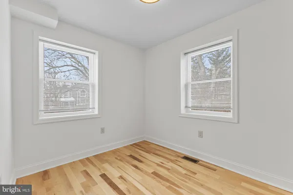 a view of a bedroom with wooden floor and a window
