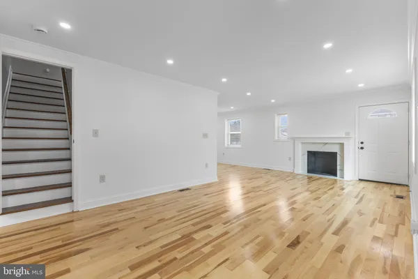 a view of empty room with wooden floor and fireplace