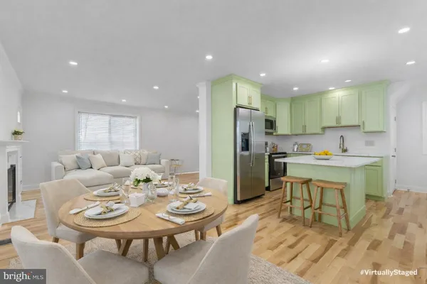a view of a dining room with furniture a rug and kitchen view