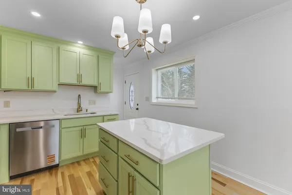 a kitchen with a sink cabinets and wooden floor