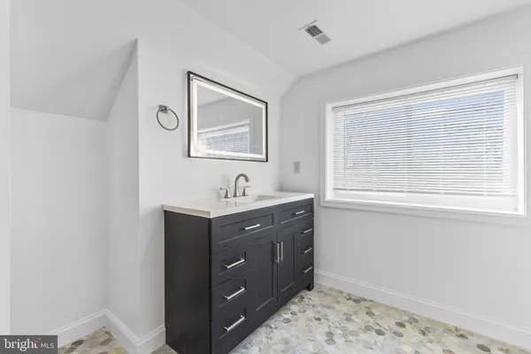 a bathroom with a sink mirror and vanity