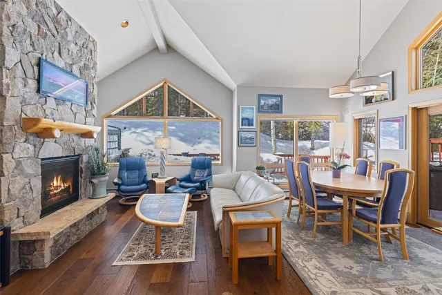 a dining room with furniture a fireplace and wooden floor