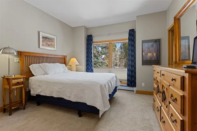 a spacious bedroom with a bed and a dresser