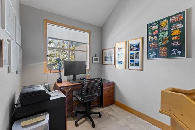 a view of a workspace with furniture and a window