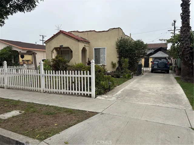 a view of a house with a small yard and wooden fence