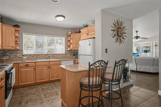 a kitchen with stainless steel appliances granite countertop a refrigerator sink and white cabinets