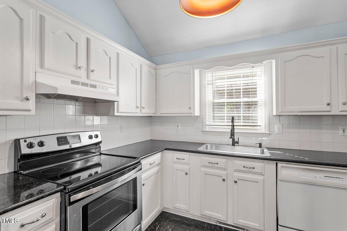 8337 Greywinds Drive Raleigh, NC 27615 - Photo 14 of 27 a kitchen with granite countertop white cabinets and appliances