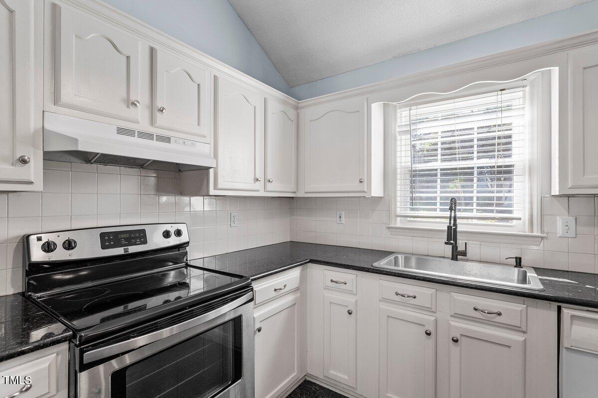 8337 Greywinds Drive Raleigh, NC 27615 - Photo 16 of 27 a kitchen with cabinets appliances a sink and a window