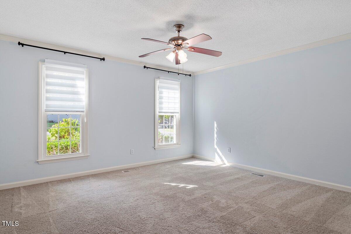 8337 Greywinds Drive Raleigh, NC 27615 - Photo 18 of 27 an empty room with window and chandelier fan
