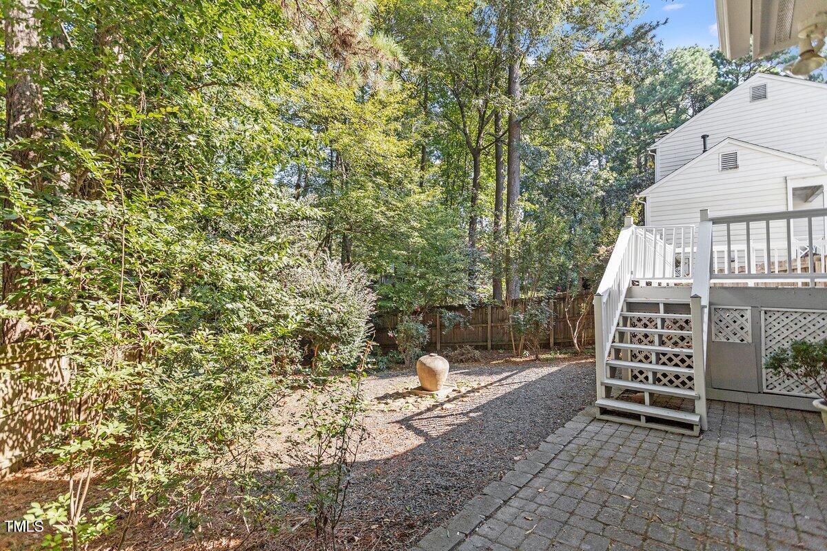8337 Greywinds Drive Raleigh, NC 27615 - Photo 27 of 27 a view of a patio with table and chairs and wooden fence