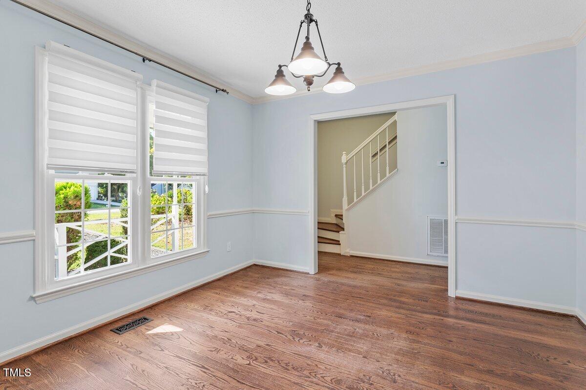 8337 Greywinds Drive Raleigh, NC 27615 - Photo 4 of 27 an empty room with wooden floor and windows