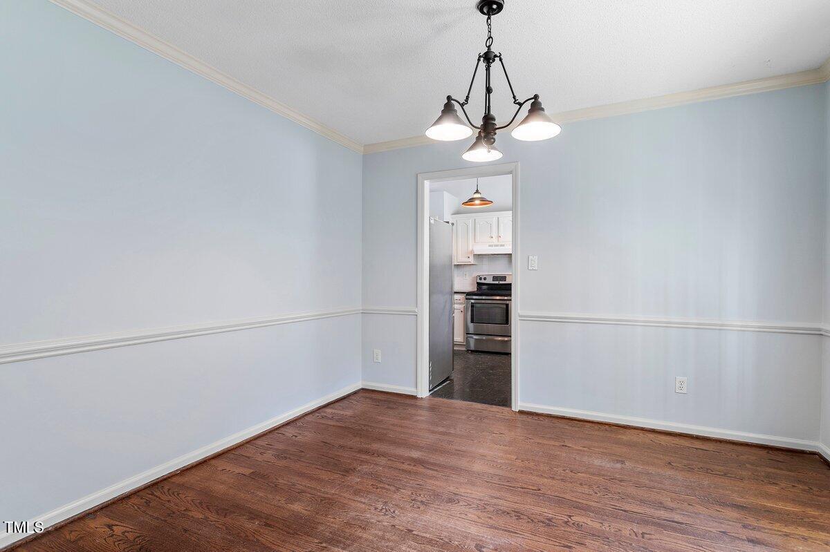 8337 Greywinds Drive Raleigh, NC 27615 - Photo 5 of 27 a view of a room with wooden floor and ceiling fan