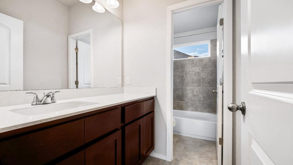 208 Stein Road Georgetown, TX 78626 - Photo 19 of 30 Full bath featuring vanity, tile patterned floors, and bathing tub / shower combination