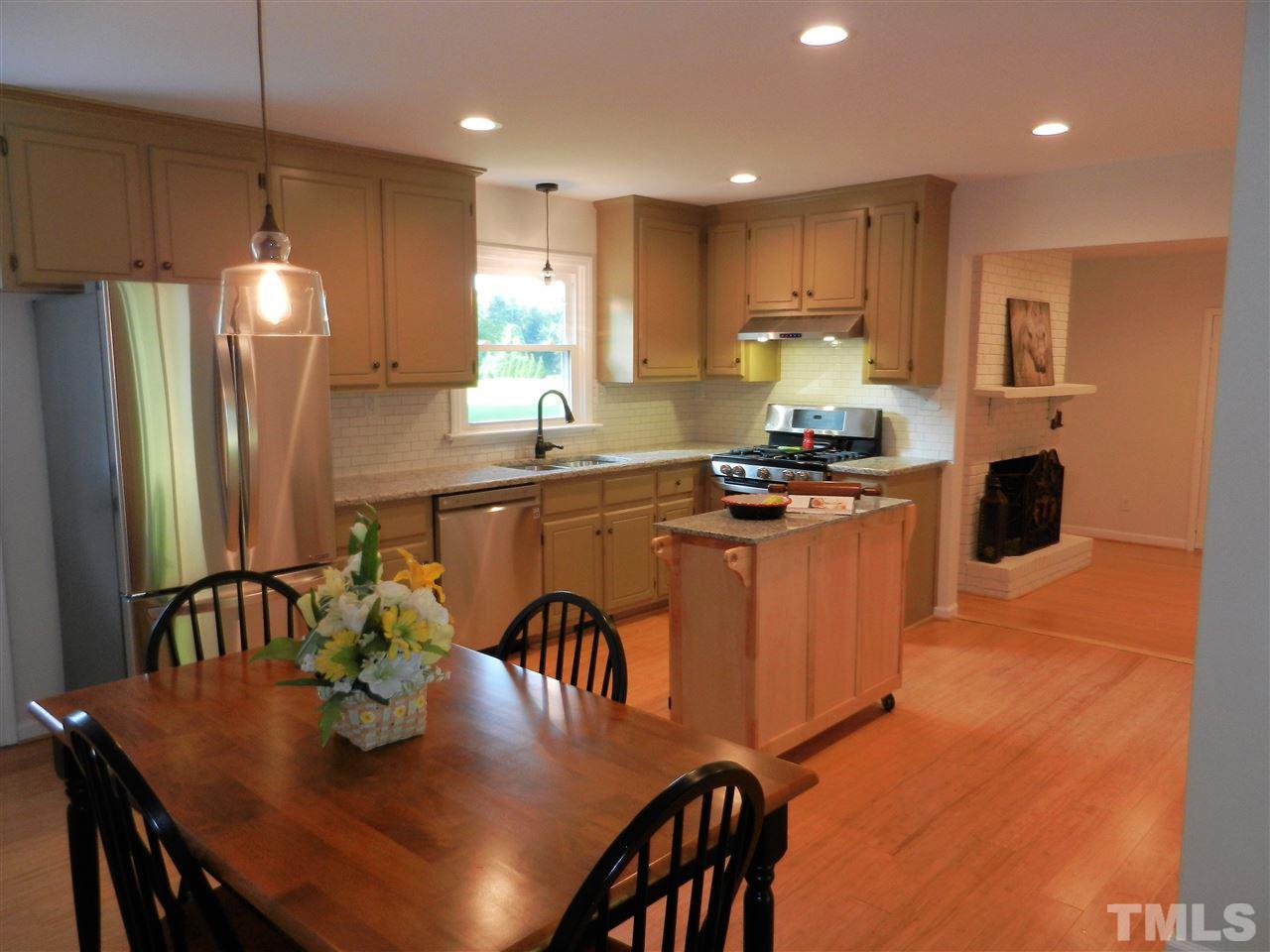 11916 Us 64 A Spring Spring Hope, NC 27882 - Photo 3 of 25 a kitchen with stainless steel appliances granite countertop a stove a refrigerator a kitchen island a dining table and chairs
