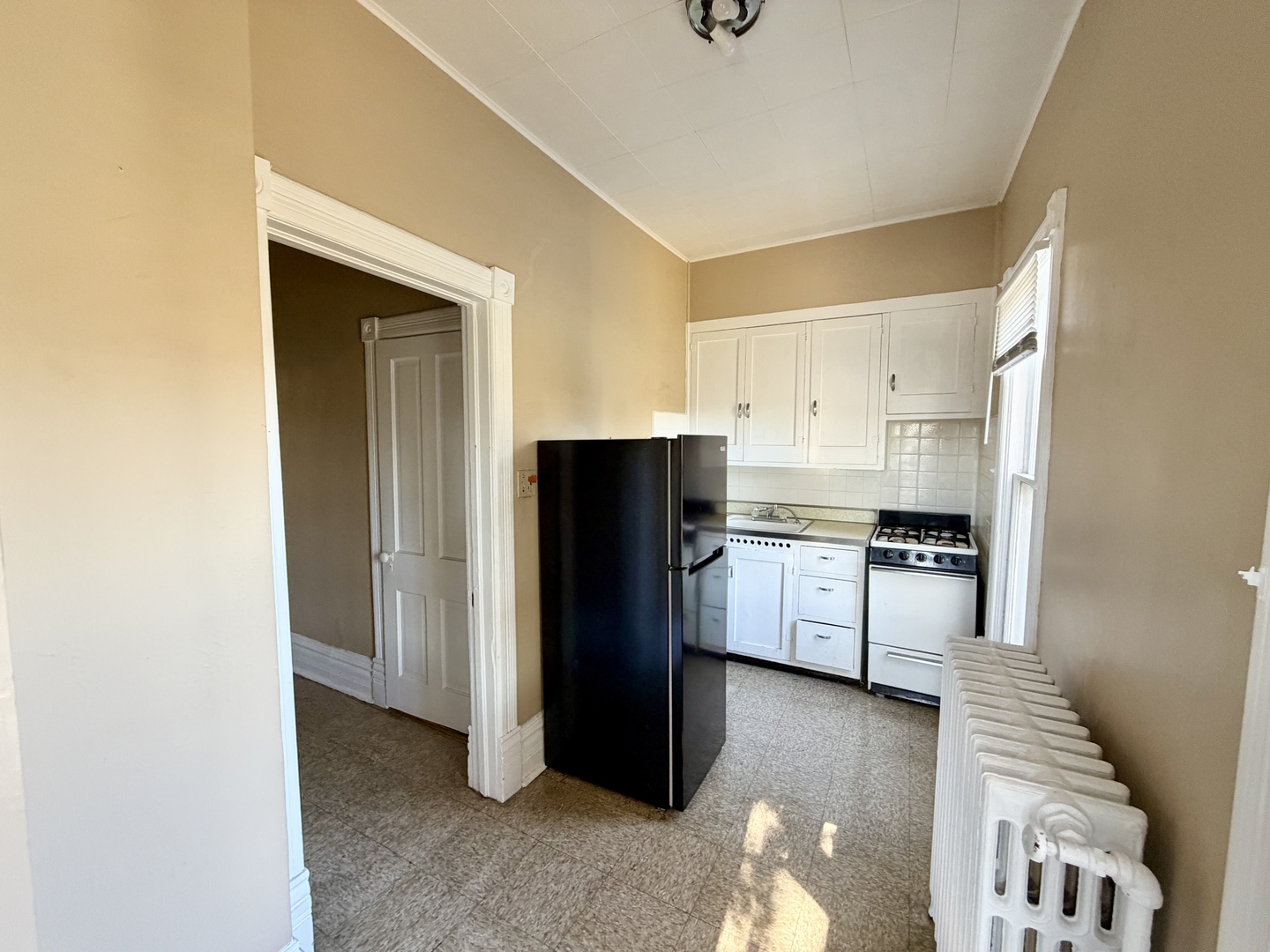 1105 Morton Avenue, Unit 3 Elgin, IL 60120 - Photo 4 of 8 a kitchen with a refrigerator and a stove top oven