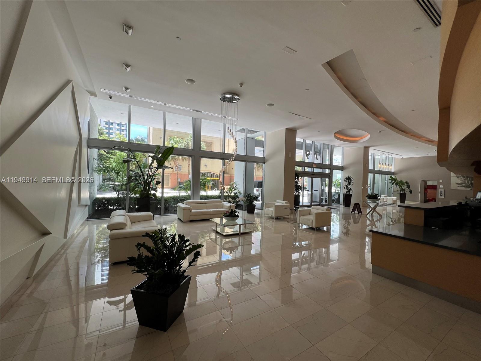 79 Southwest 12th Street, Unit 1704S Miami, FL 33130 - Photo 5 of 20 a very nice looking living room with a large window and potted plants
