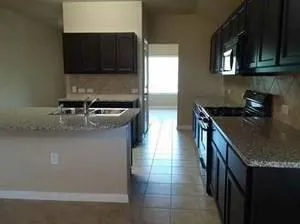 a kitchen with stainless steel appliances granite countertop a sink a stove and a microwave