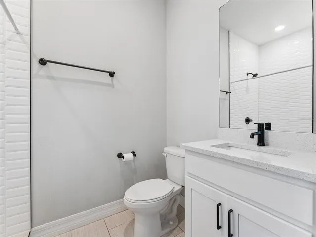 a bathroom with a sink toilet vanity and shower