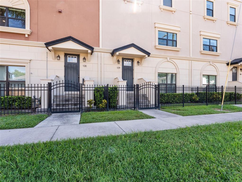 3421 West Horatio Street, Unit 109 Tampa, FL 33609 - Photo 2 of 20 a view of a white house with a yard and table and chairs under an umbrella