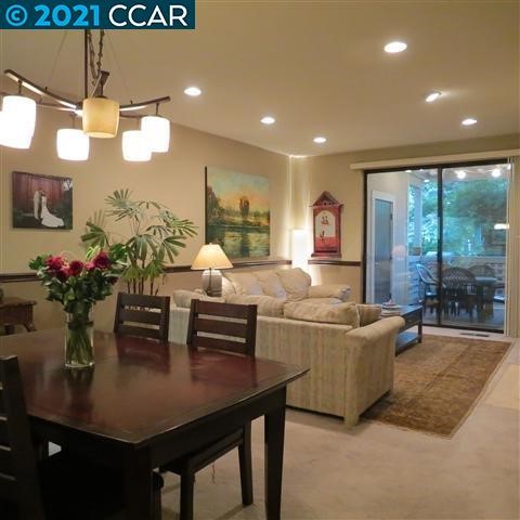 a living room with couches a dining table and chairs with potted plants
