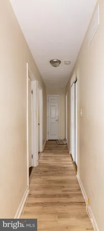 a view of a room with wooden floor and a bathroom