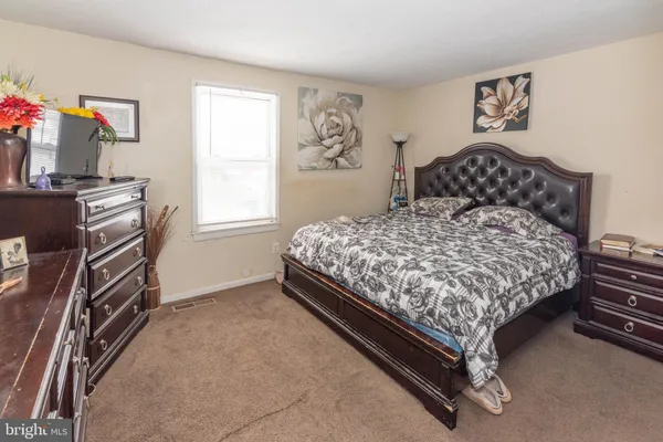 a bedroom with a bed and dresser with window