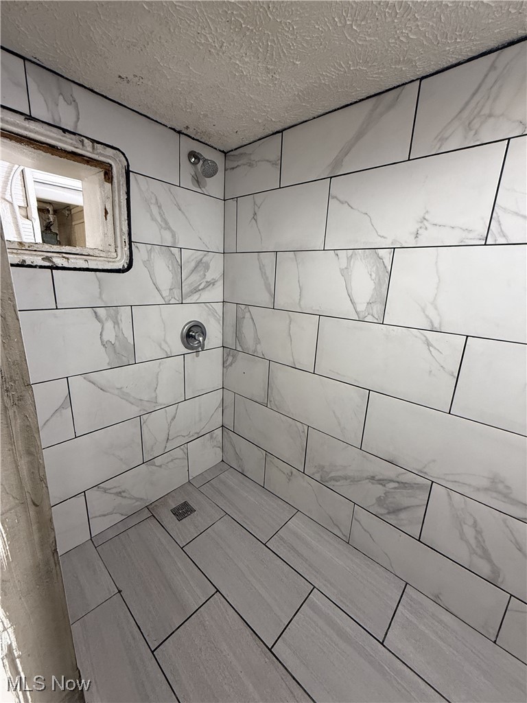 877 Garfield Street Akron, OH 44310 - Photo 5 of 16 Full bath with a tile shower and a textured ceiling