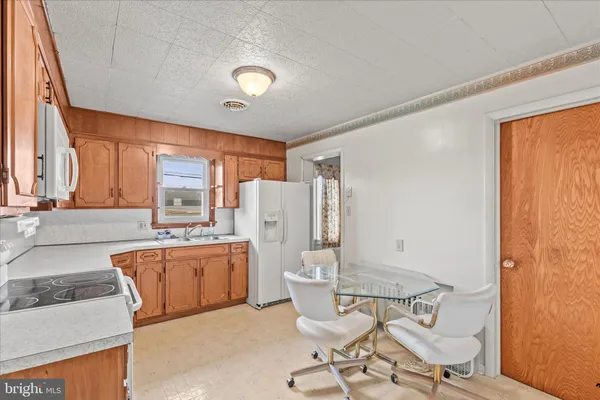 a kitchen with stainless steel appliances kitchen island granite countertop furniture and a refrigerator