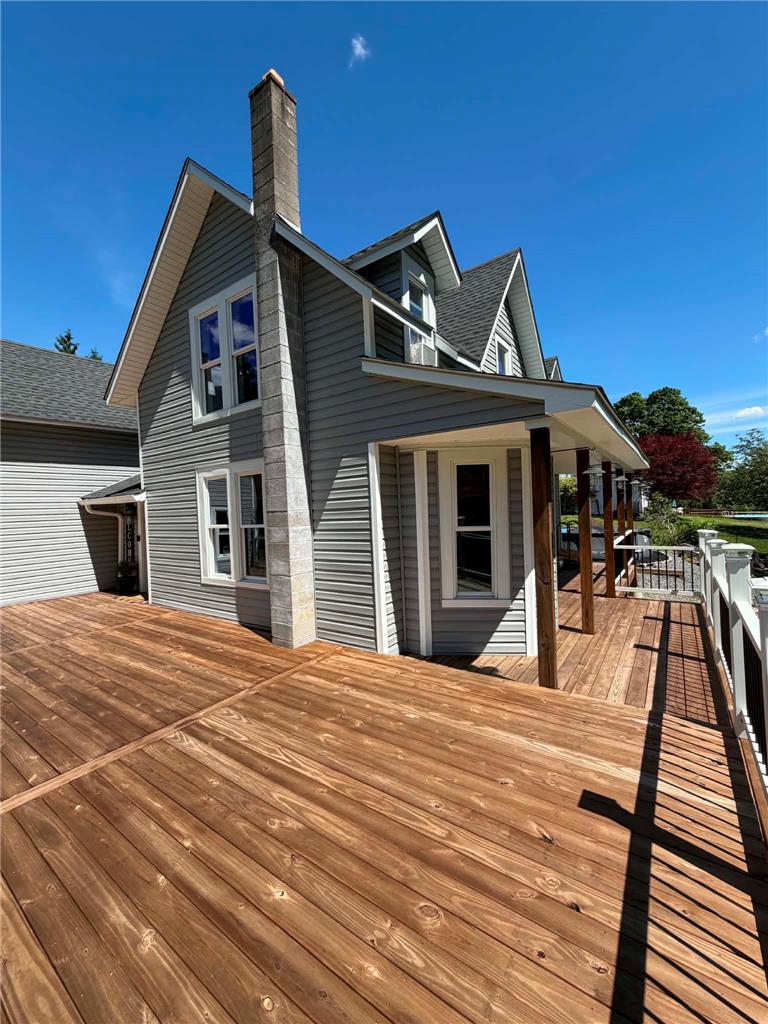 164 Sand Spring Road Cresco, PA 18326 - Photo 13 of 60 A newly constructed wood deck provides ample outdoor living space alongside a charming gray-sided home.