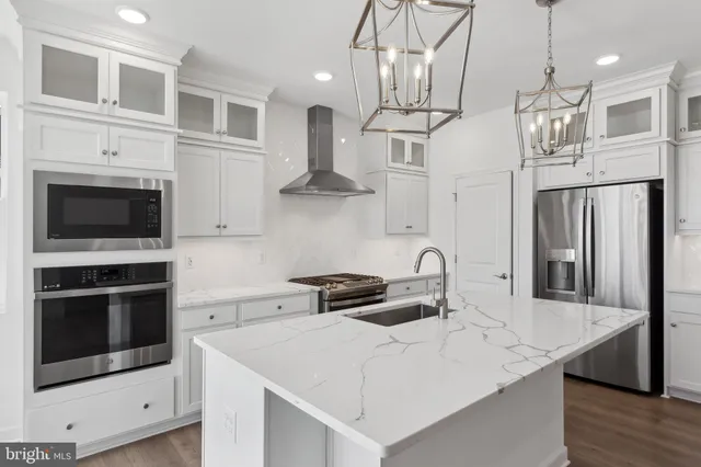 a kitchen with stainless steel appliances a stove a sink and a microwave