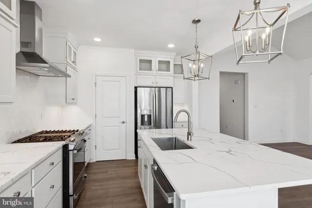 a kitchen with stainless steel appliances a sink stove and refrigerator
