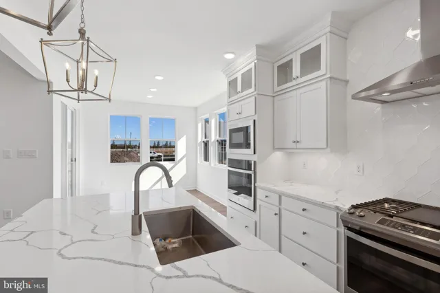 a kitchen with granite countertop a sink stainless steel appliances and cabinets