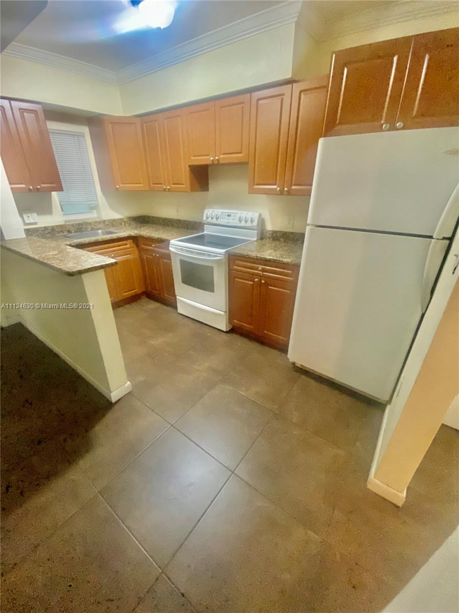 520 Northeast 82nd Terrace, Unit 7 Miami, FL 33138 - Photo 3 of 11 a kitchen with granite countertop a sink and a stove top oven