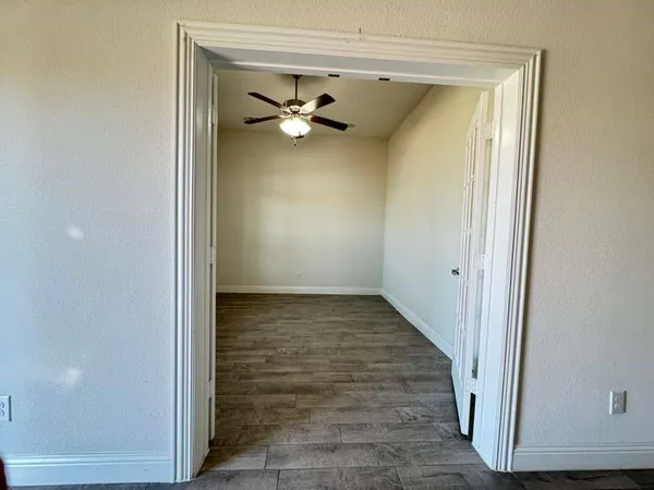 a view of empty room with wooden floor and fireplace