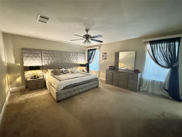 a spacious bedroom with a bed a couch and dresser