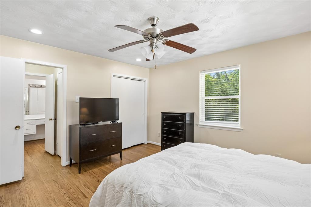 8049 Woodhue Road Dallas, TX 75228 - Photo 18 of 24 a bedroom with a bed and a flat screen tv