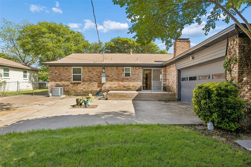 8049 Woodhue Road Dallas, TX 75228 - Photo 24 of 24 a view of a backyard with table and chairs under an umbrella