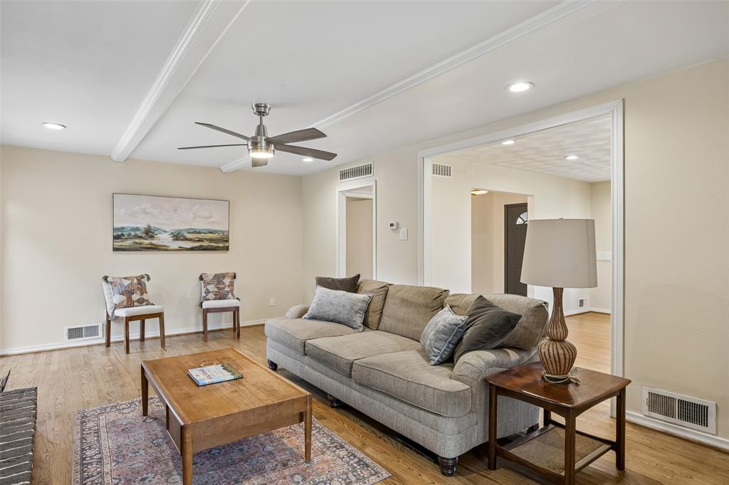 8049 Woodhue Road Dallas, TX 75228 - Photo 4 of 24 a living room with furniture a rug and a chandelier